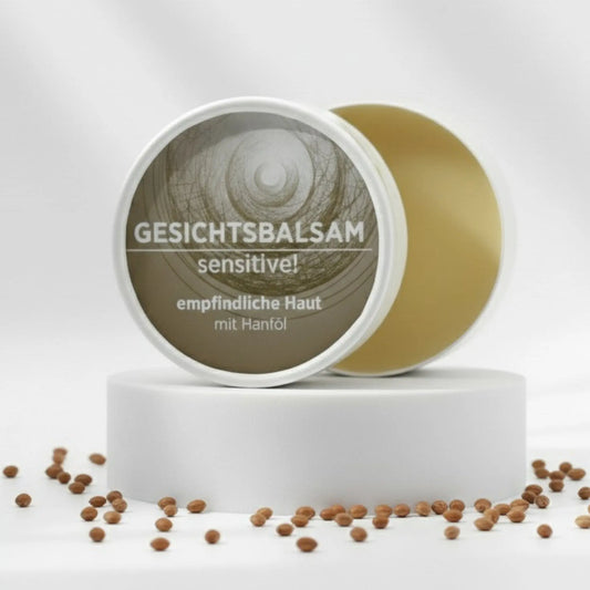 Gesichtsbalsam mit natürlichen Inhaltsstoffen für empfindliche Haut ohne Duftstoffe, Gesichtsbalsam ist in weißem, zylindrischem Karton verpackt mit beigem Etikett.