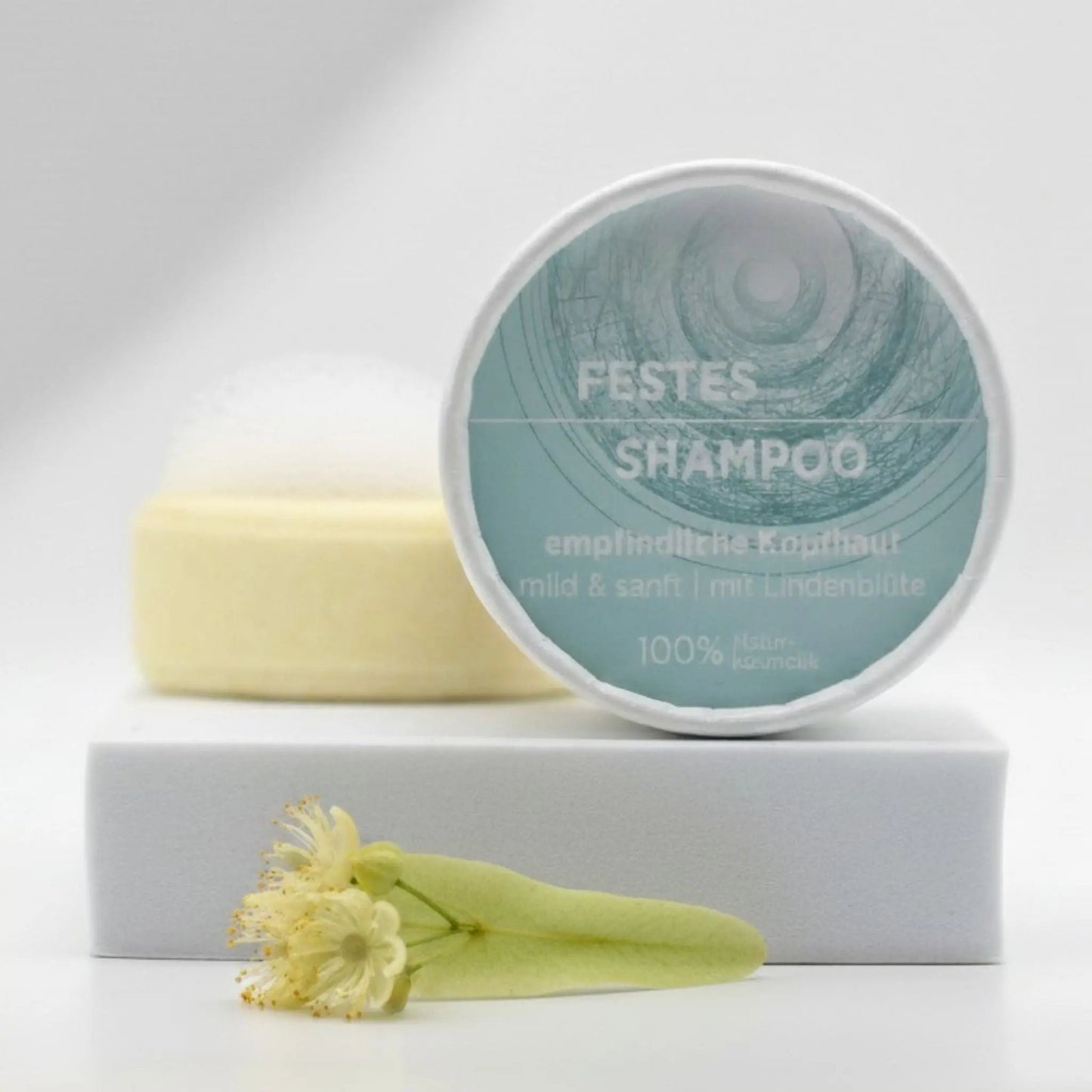 Veganes festes Shampoo für empfindliche Kopfhaut von Sonnengrün – natürliche, plastikfreie Haarpflege für sensible Kopfhaut auf weißem Podest