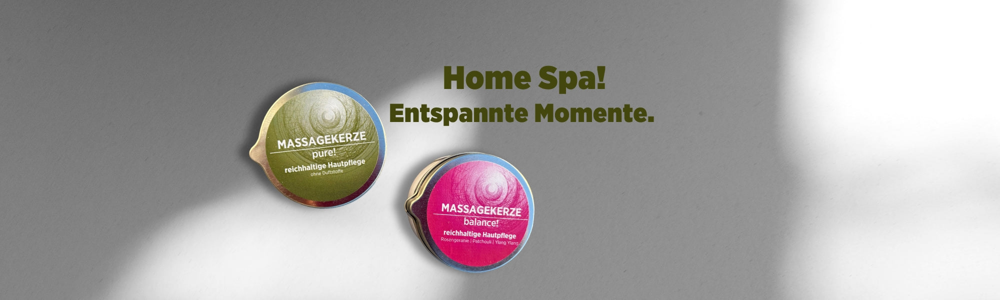 Auf dem Banner sieht man die beiden Massagekerzen von Sonnengrün vor einer weißen Wand mit Schattenspiel. Mit dunkelgrüner Schrift ist zu lesen "Home Spa! Entspannte Momente."