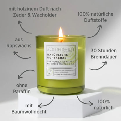 Auf diesem Foto sieht man die Duftkerze von Sonnengrün in einem grünem Glas auf einem weißen Podest stehen. Zudem sind rund um die Kerze mit dunkler Schrift die Vorteile der natürlichen Duftkerze angeführt.
