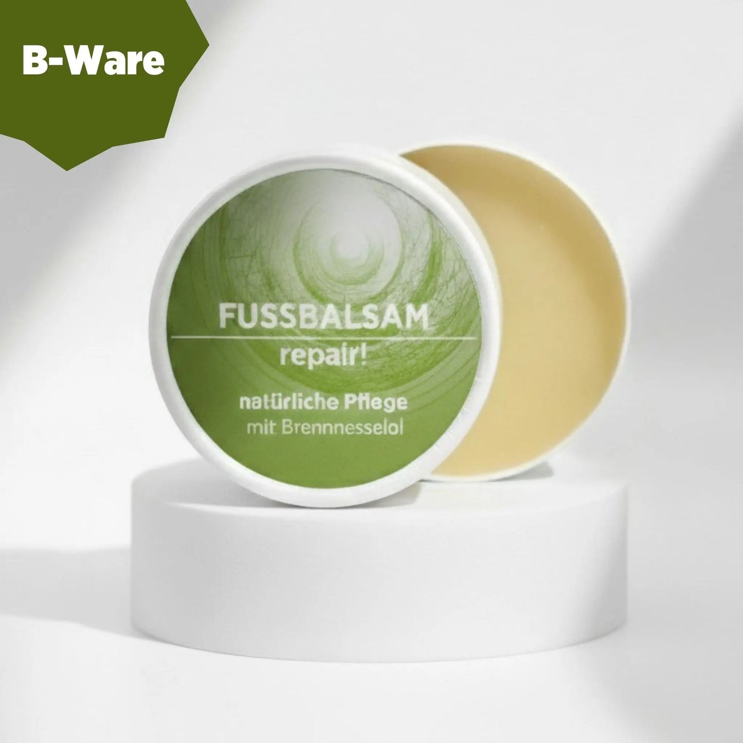 Fußbalsam mit natürlichen Inhaltsstoffen für rissige Hornhaut mit Brennnesselöl, Gesichtsbalsam ist in weißem, zylindrischem Karton verpackt mit grünem Etikett. B-Ware - Inhalt in Ordnung, Verpackung leicht beschädigt.