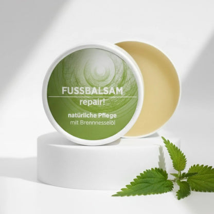 Fußbalsam mit natürlichen Inhaltsstoffen für rissige Hornhaut mit Brennnesselöl, Gesichtsbalsam ist in weißem, zylindrischem Karton verpackt mit grünem Etikett.
