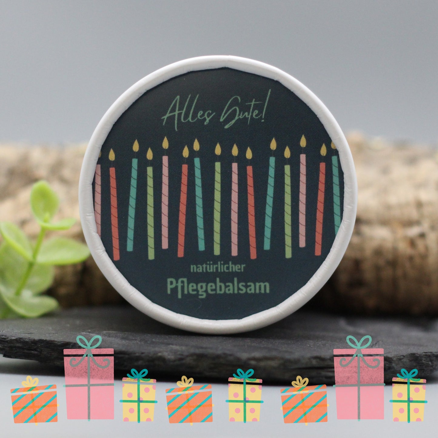 Auf dem Bild sieht man den Pflegebalsam mit einem Etikett, gestaltet speziell für Geburtstage. Auf dem Etikett sich man bunte Kerzen und die Aufschrift "Alles Gute!" und "natürlicher Pflegebalsam". Das Etikett macht den Körperbalsam zum perfekten Geburtstagsgeschenk.